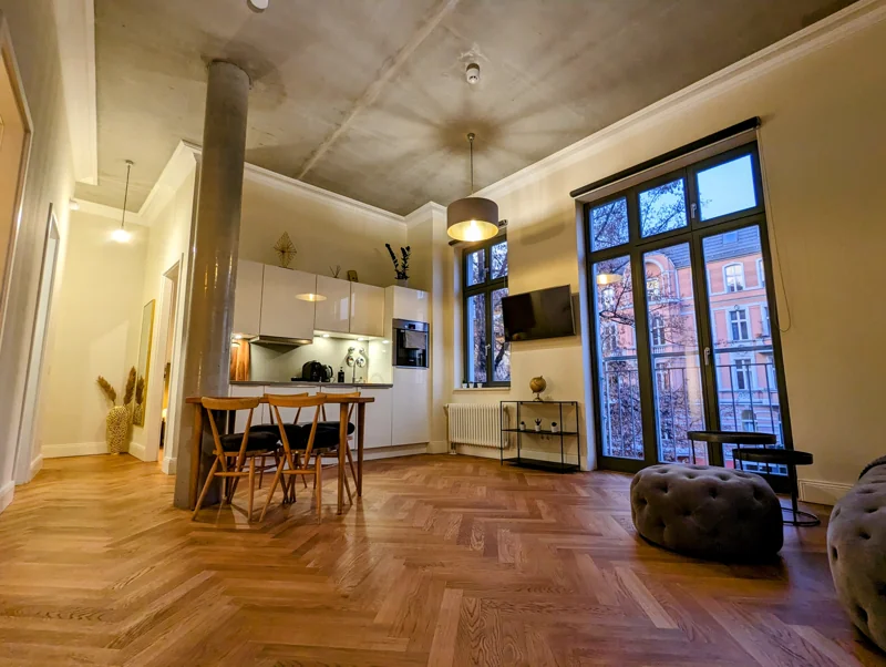 Open kitchen and dining table beside floor-to-ceiling windows